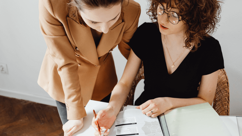 deux femmes s'entraident pour remplir des documents
